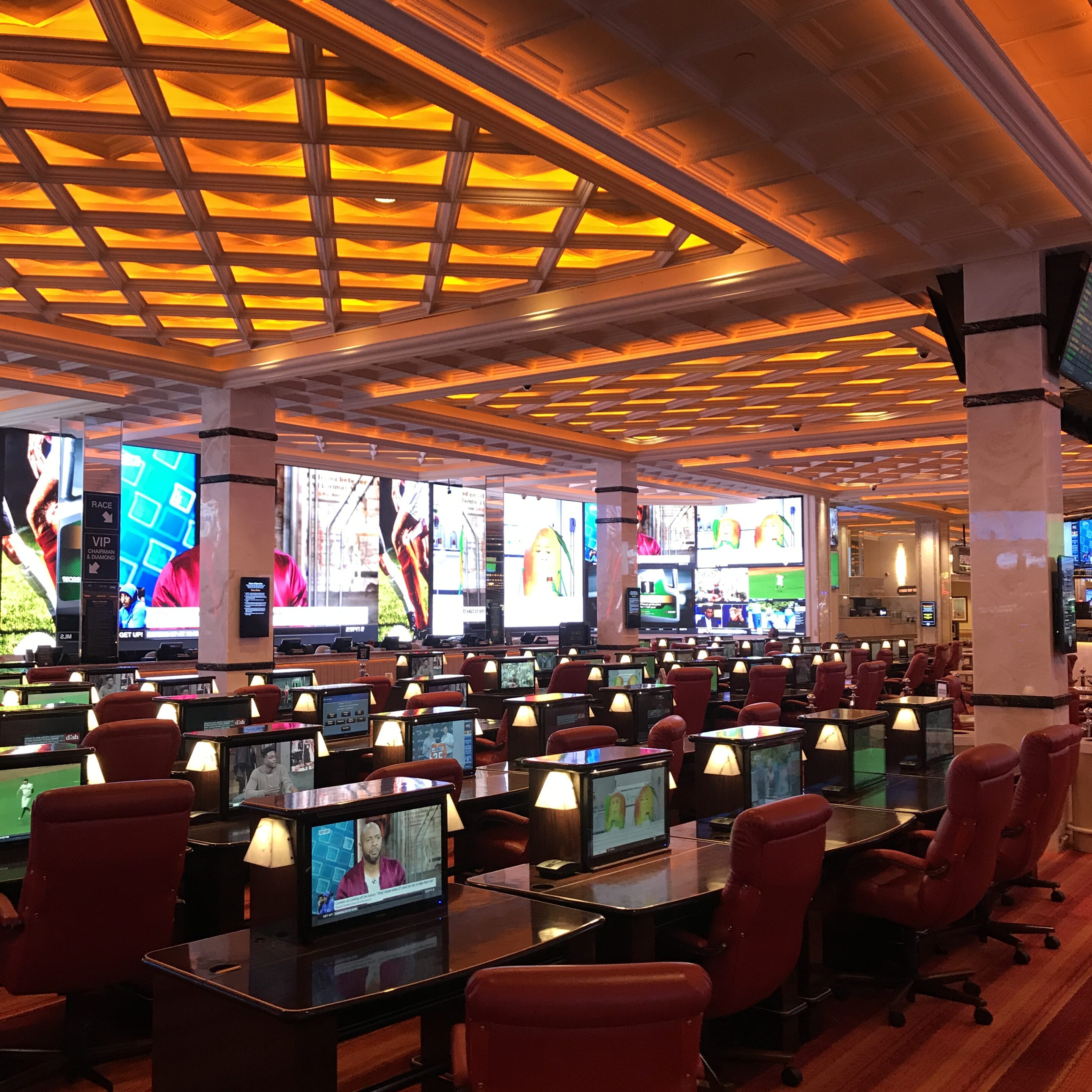 Casino sportsbook seating and screens representing betting ban scam risk and licensed sportsbook checks