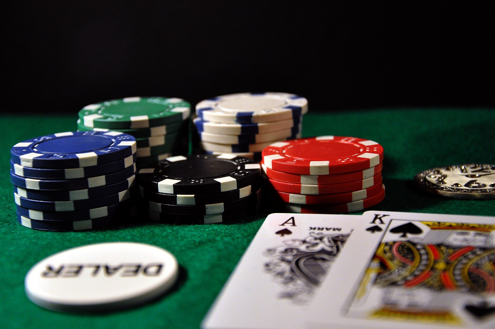 Playing cards and tokens representing casino bonus game contribution percentages