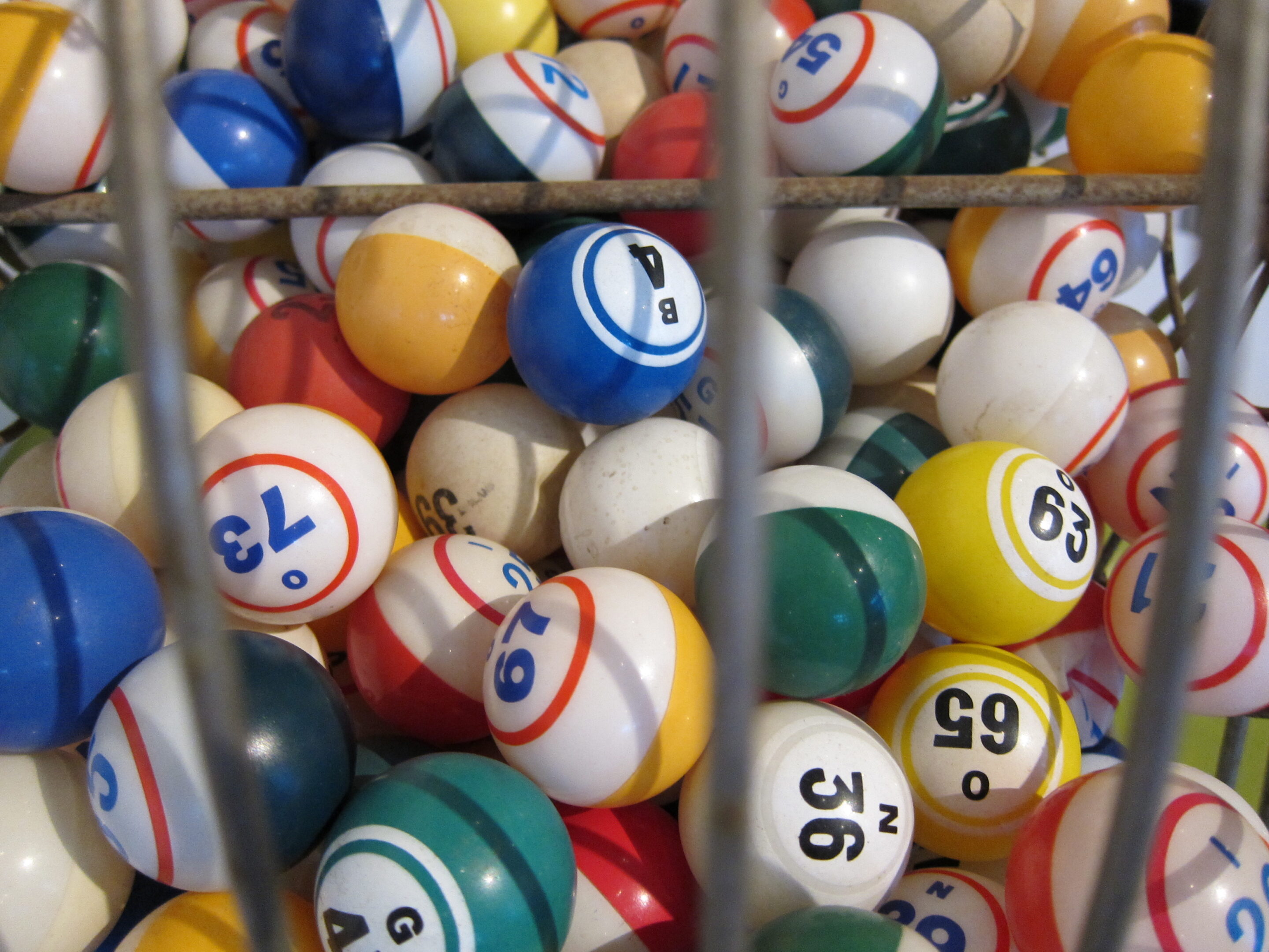 Numbered lottery balls in a draw drum representing a lottery budget before a jackpot campaign