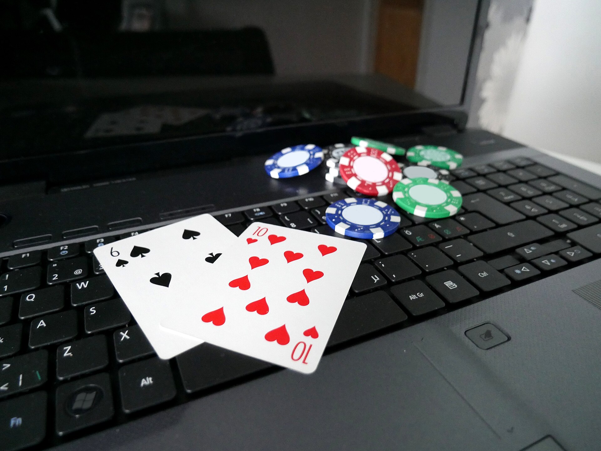 Laptop with poker cards and chips representing a gambling deposit limit review