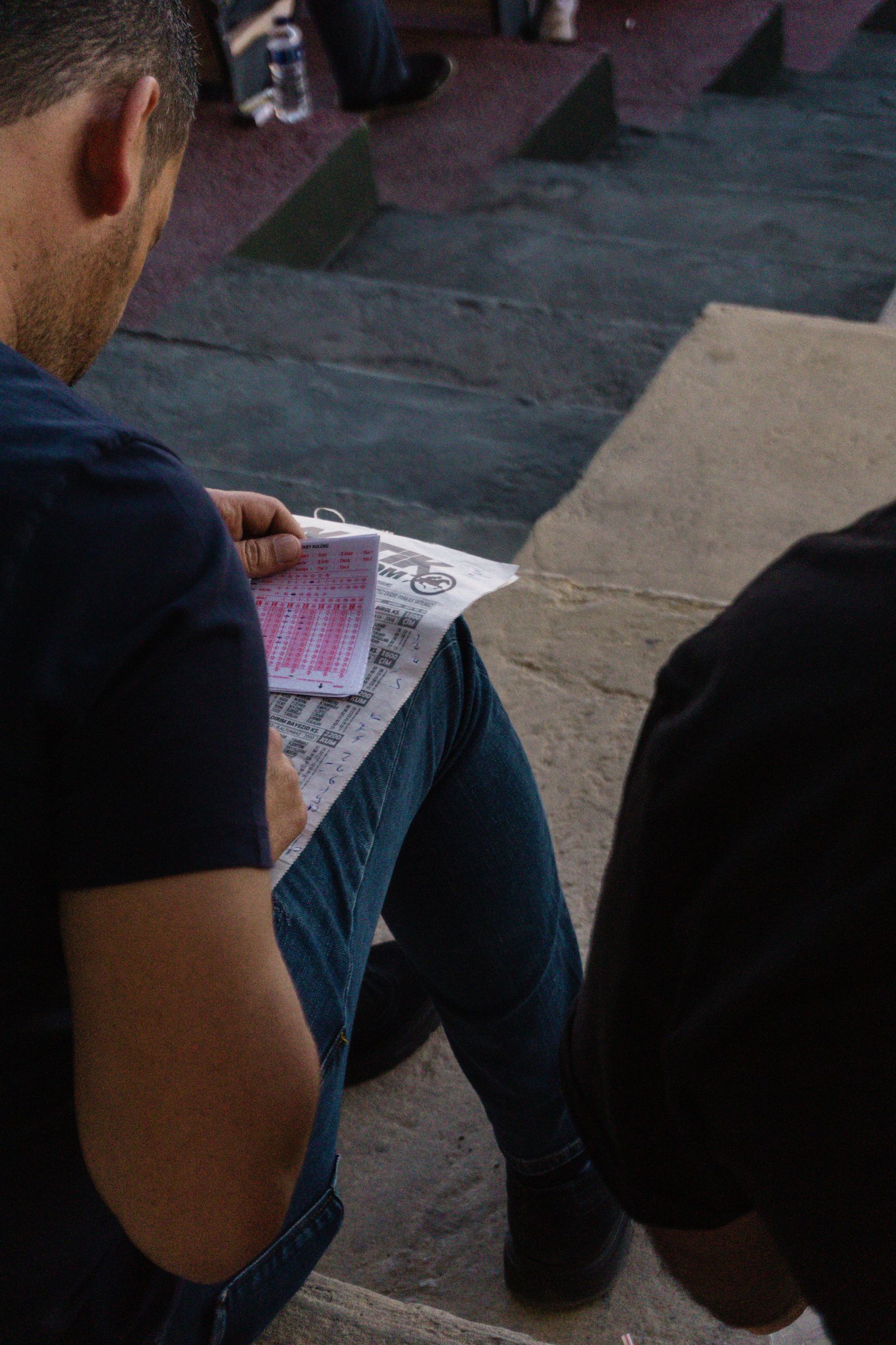 Man reading a racing form representing a checklist before using a new sportsbook