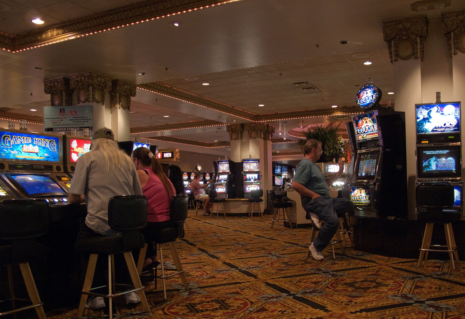 Players at slot machines representing a safer-play prompt before the next bet