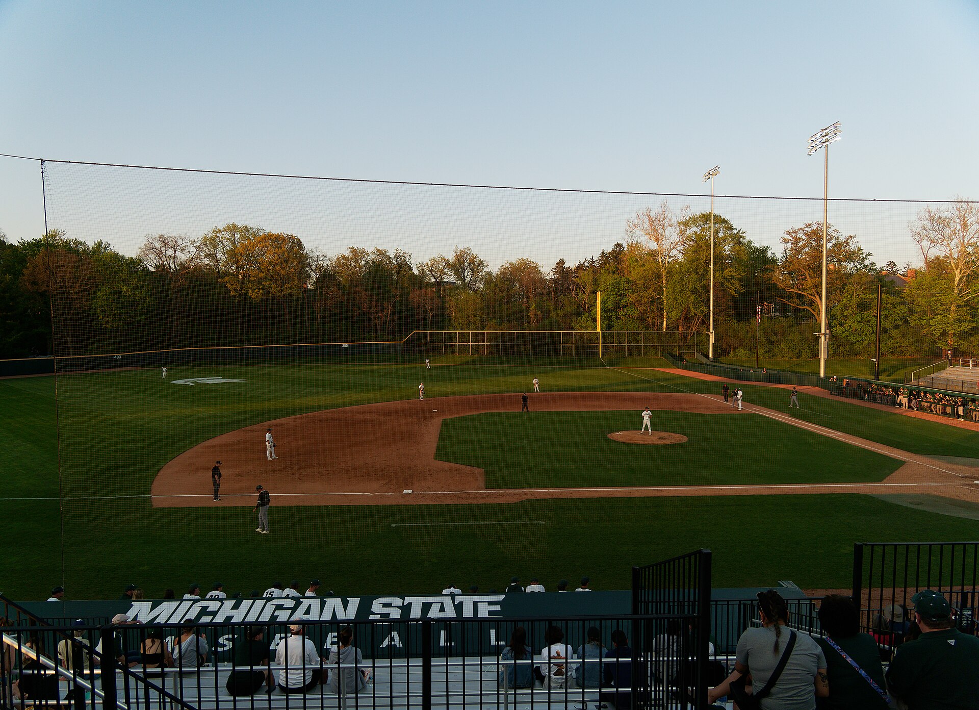 Baseball game at McLane Baseball Stadium with pitcher, fielders and spectators